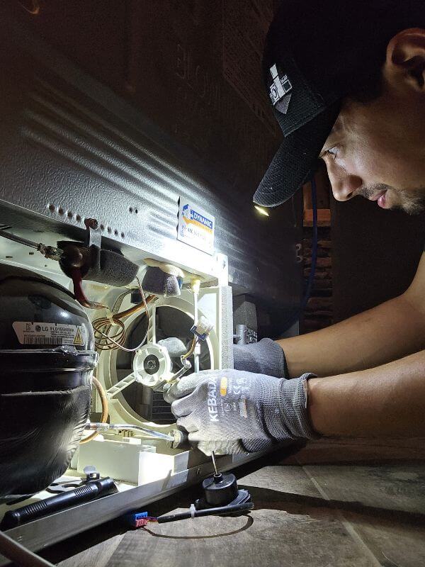 East Valley Location Page Someone repairing a dryer with the back open and parts showing by Dynamic Appliance Repair