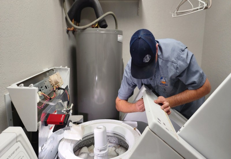 The technician is repairing the washer by inspecting internal components in Surprise, AZ<br />
