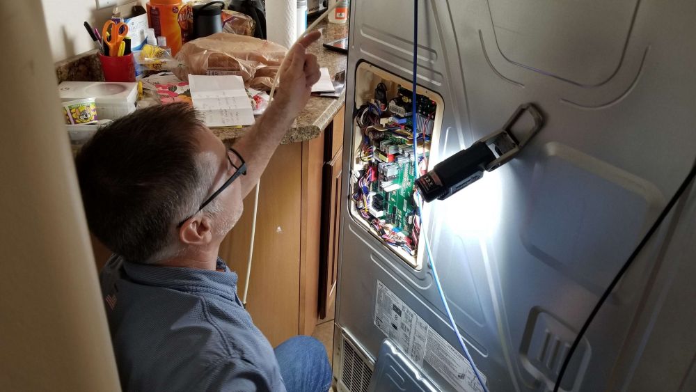 Dynamic Appliance Repair Technician Repairing Freezer