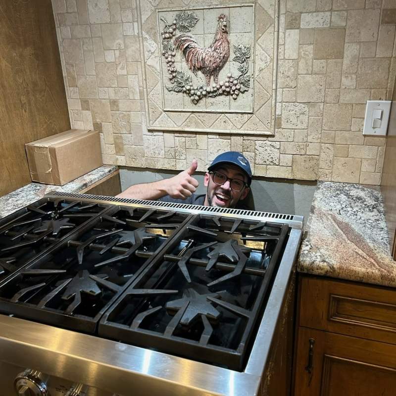 Technician repairing a refrigerator interior with a cordless drill in Gilbert & Fountain Hills, AZ<br />
